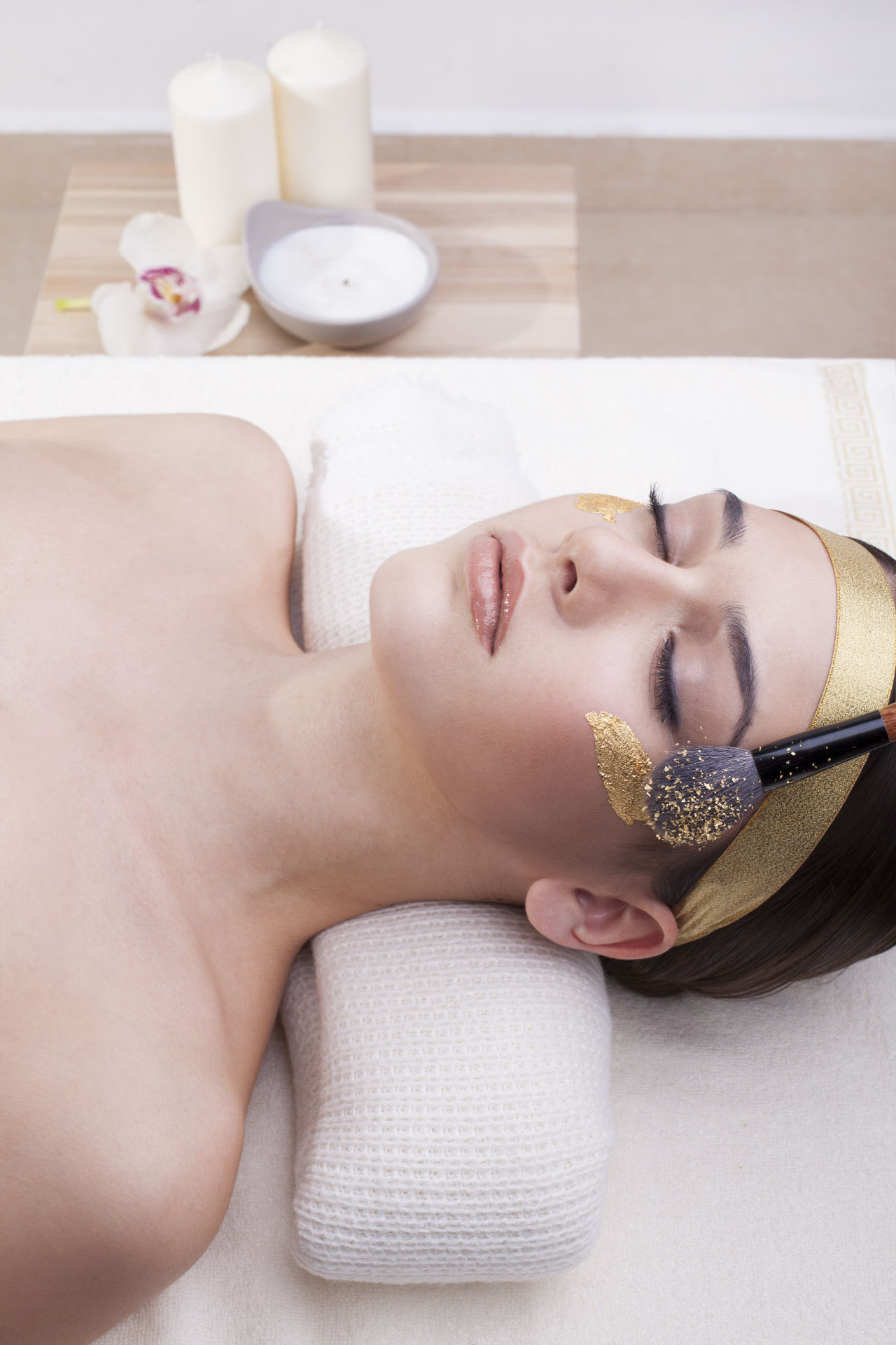Gold Cosmetics and Skin Care Woman enjoying gold cosmetics and skin care.